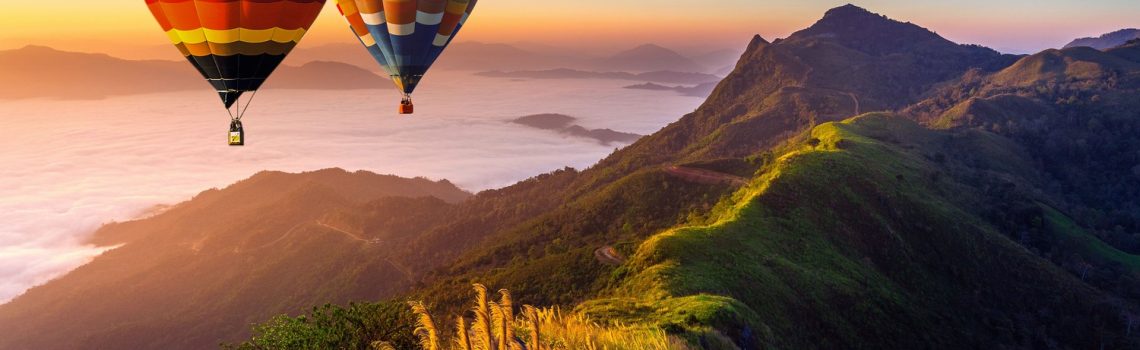 paisagem-de-nevoeiro-matinal-e-montanhas-com-baloes-de-ar-quente-ao-nascer-sol